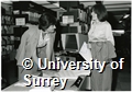 Photographs of two men using a computer in the University of Surrey Library, and a member of Library staff issuing books to a woman