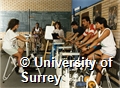 Photograph of students on exercise bikes in the weight training room in the sports hall at the University of Surrey