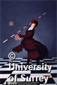 Performance shot of Yolande Snaith dancing on chequered floor holding a pole.